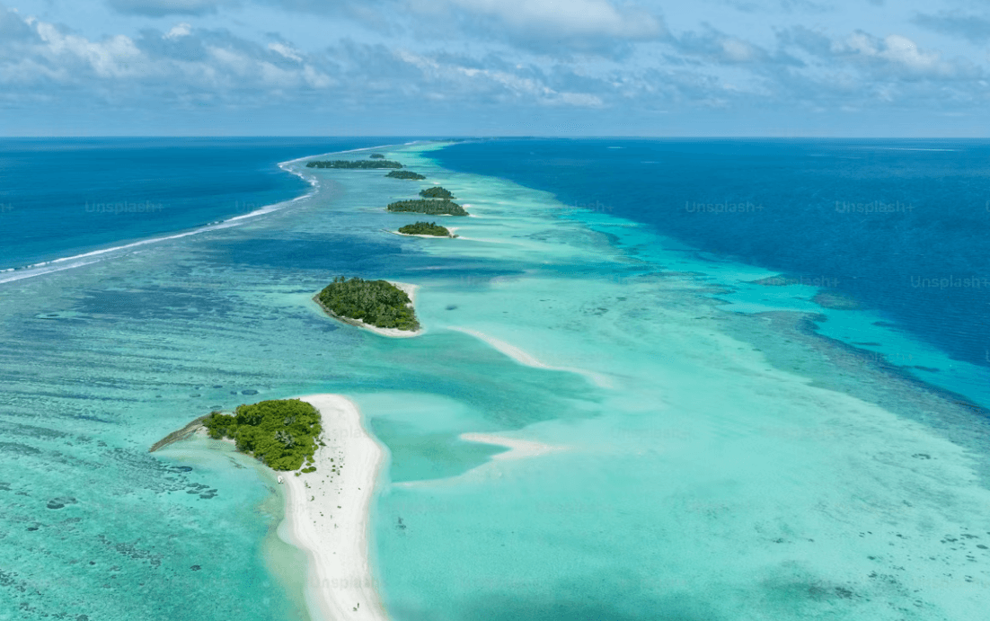 Aerial view of Maldives atolls and coral reefs surrounded by turquoise ocean